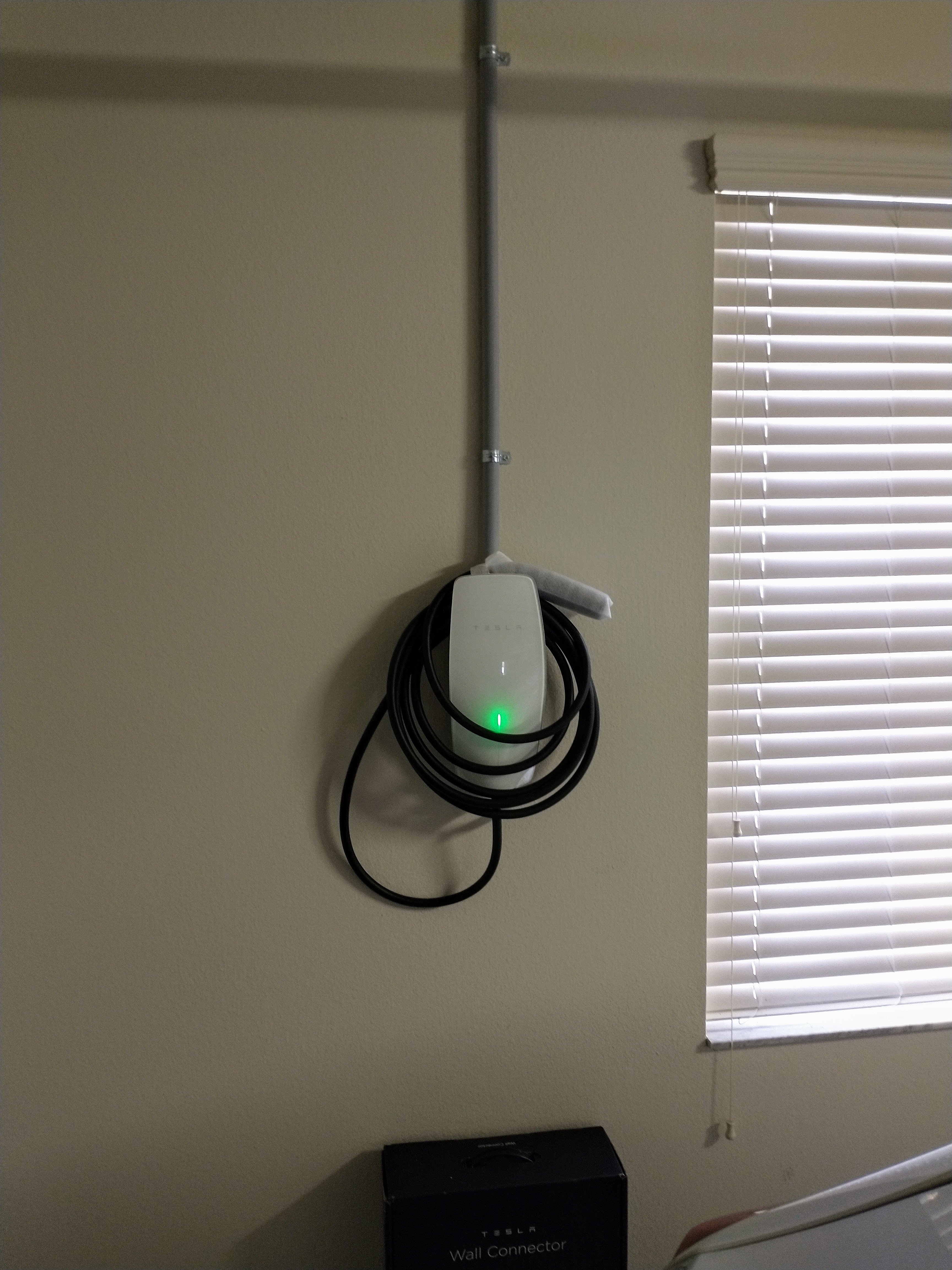 Tesla Wall Connector home EV charger installed in a residential garage