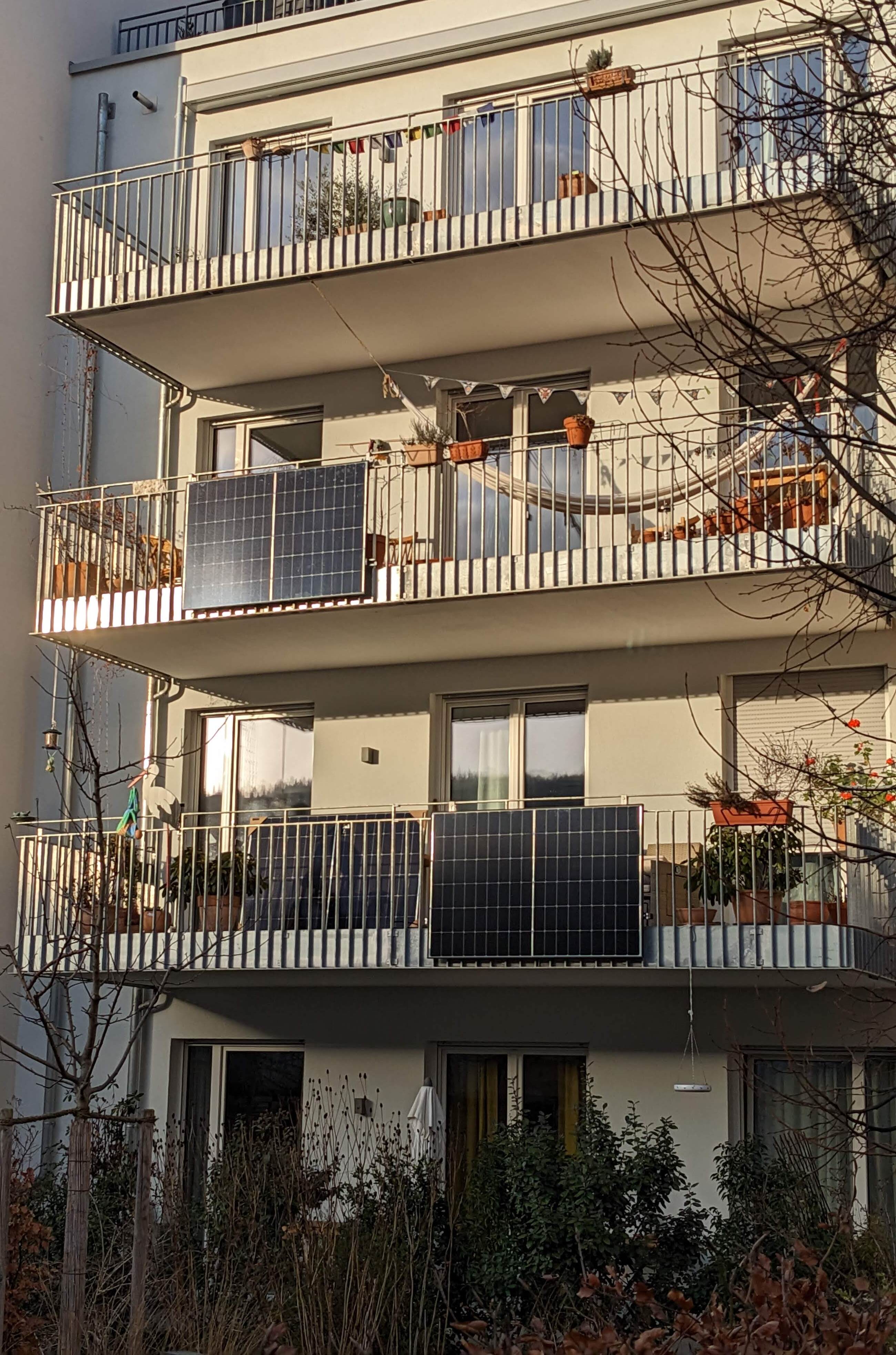 Balcony solar panels mounted on an apartment railing